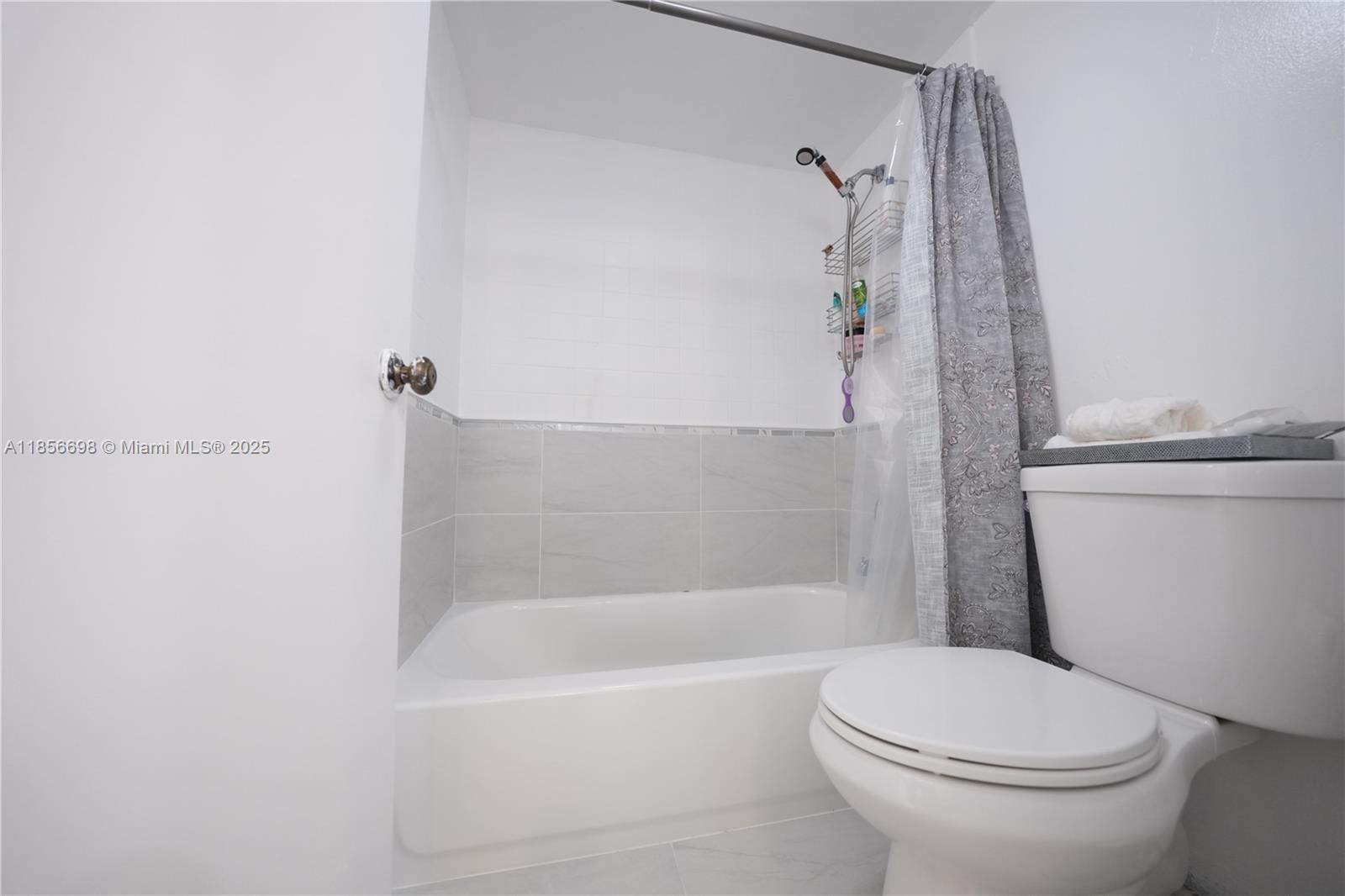 21121 Southwest 85th Avenue, Unit 117 Cutler Bay, FL 33189 - Photo 12 of 15 a white toilet sitting next to a bath tub