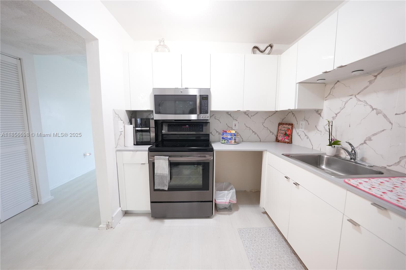 21121 Southwest 85th Avenue, Unit 117 Cutler Bay, FL 33189 - Photo 5 of 15 a kitchen with a sink stove and microwave