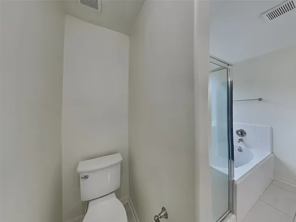 a white toilet sitting next to a shower