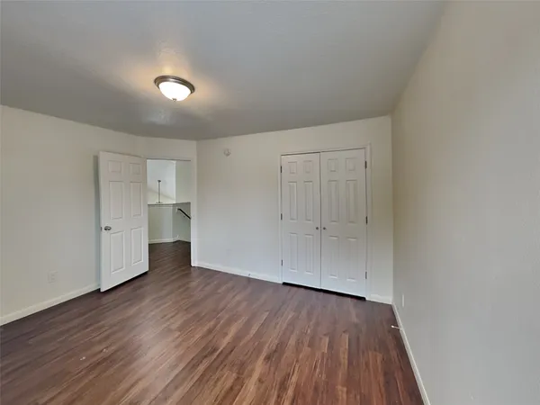 a view of empty room with wooden floor and cabinet