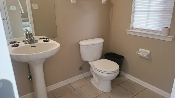a bathroom with a sink toilet and a mirror