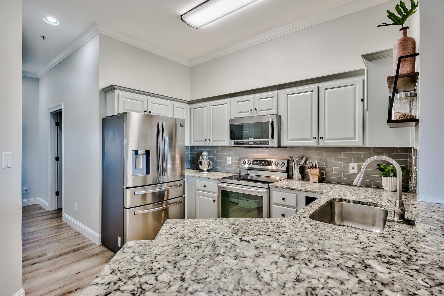 4507 Furling Lane, Unit 302 Destin, FL 32541 - Photo 1 of 15 a kitchen with stainless steel appliances granite countertop a refrigerator stove microwave and sink