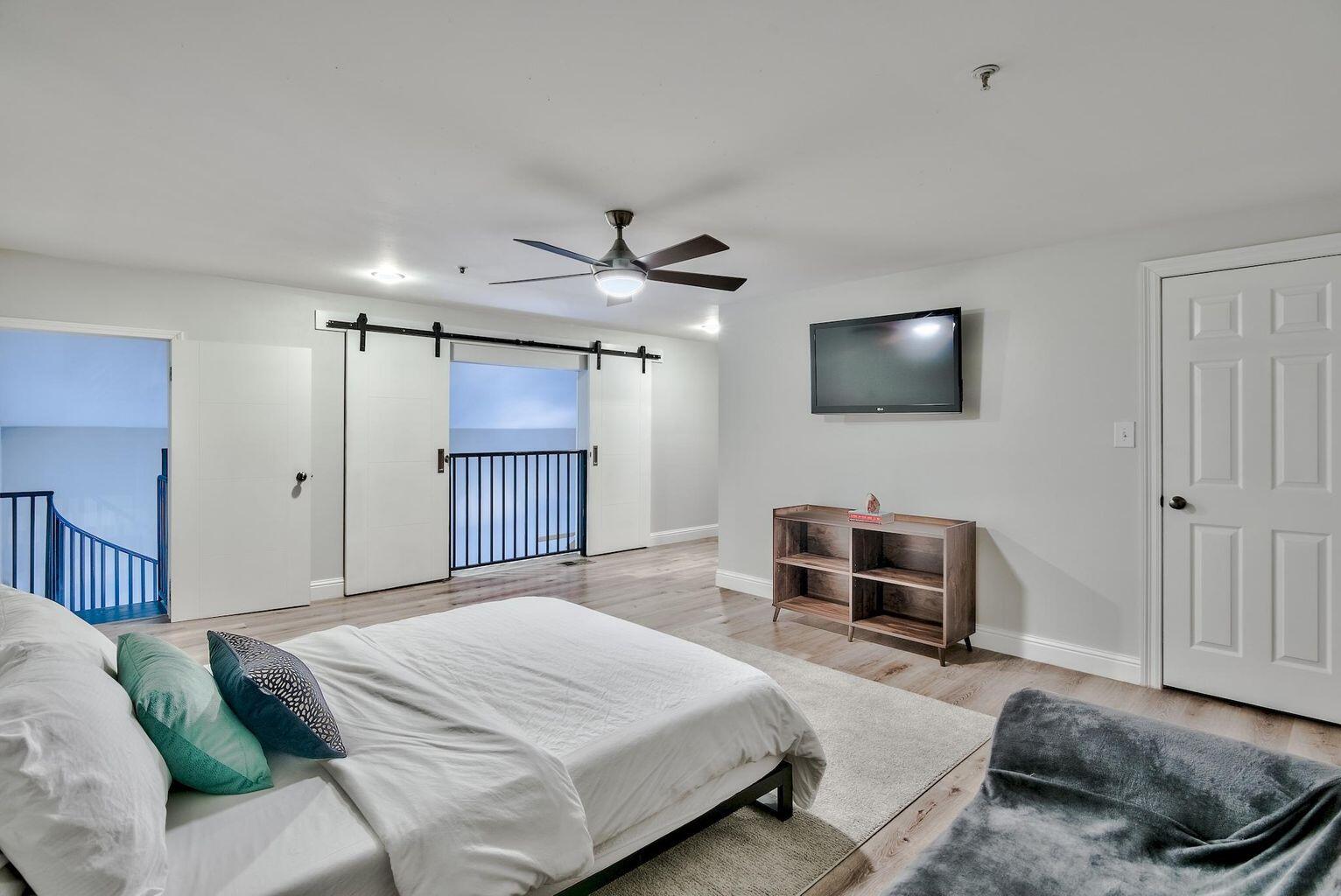 4507 Furling Lane, Unit 302 Destin, FL 32541 - Photo 12 of 15 a bedroom with a large bed a flat tv screen and a dresser