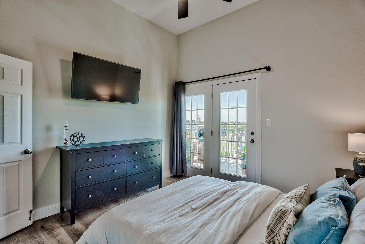 4507 Furling Lane, Unit 302 Destin, FL 32541 - Photo 6 of 15 a bedroom with a bed and a flat screen tv