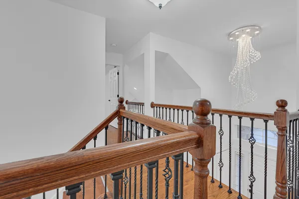 a view of staircase with railing and white walls