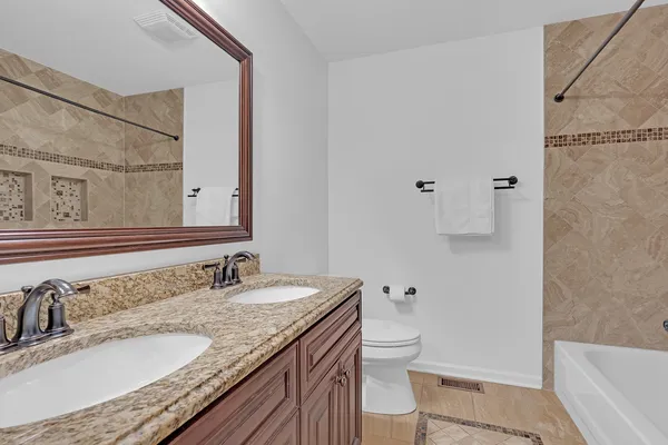 a bathroom with a granite countertop sink toilet and shower