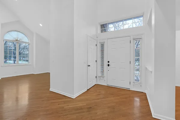 a view of empty room with window and wooden floor