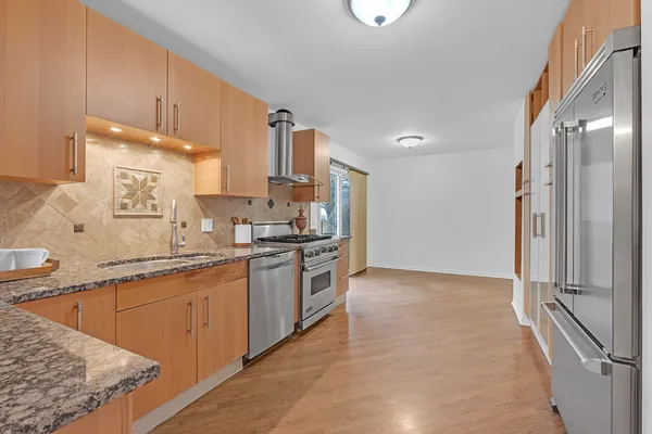 a kitchen with stainless steel appliances granite countertop a sink stove and refrigerator