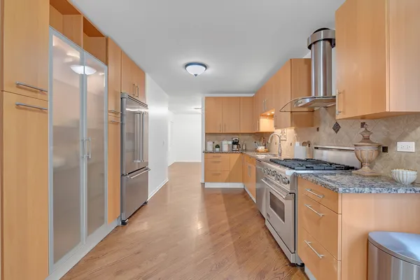a large kitchen with stainless steel appliances granite countertop a stove a sink and a refrigerator