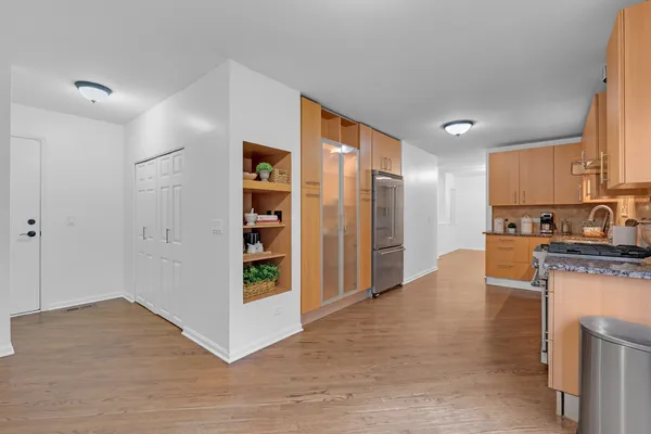a view of kitchen with stainless steel appliances granite countertop a refrigerator and a stove top oven