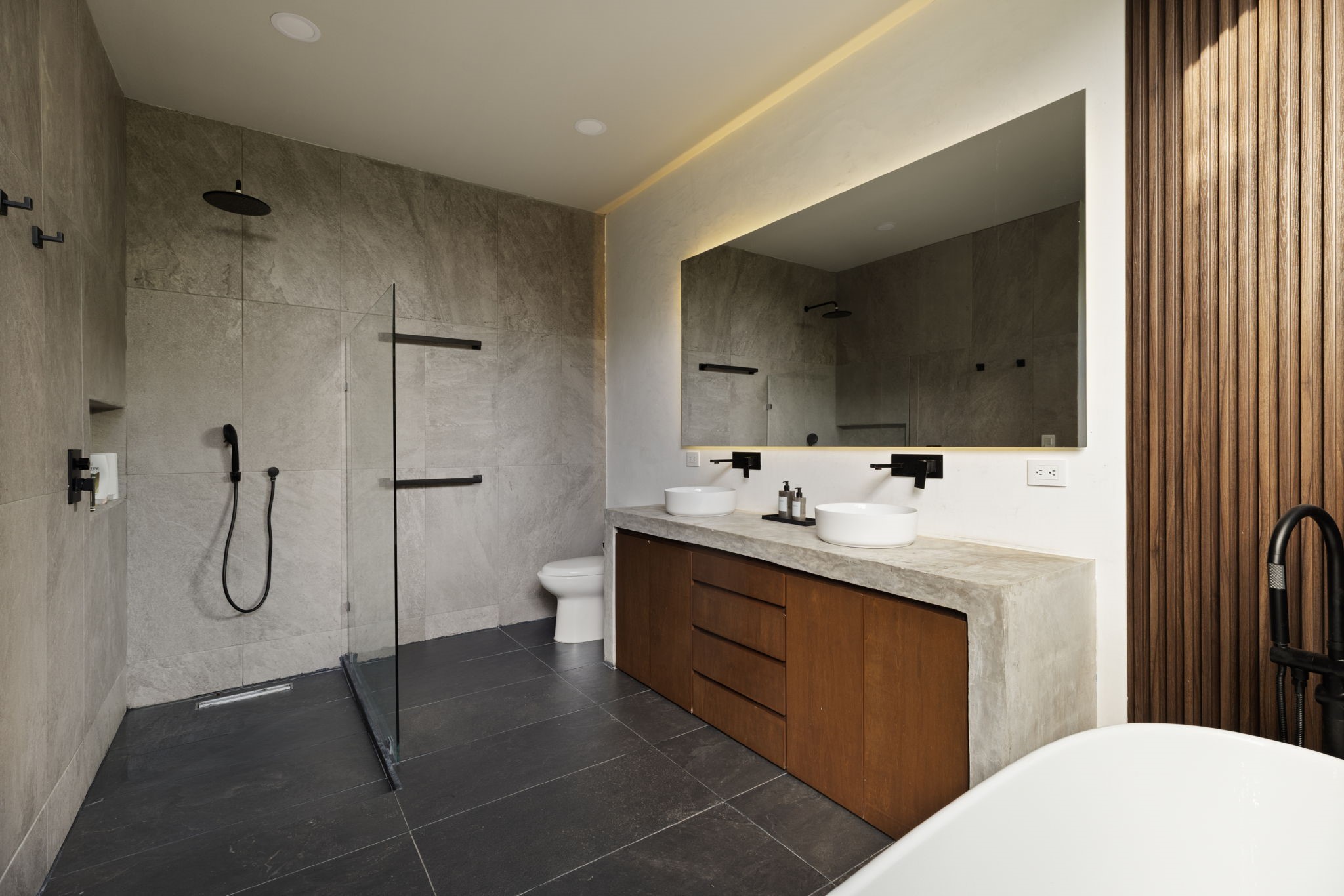 6 Country Club, Unit 4 Nome, TX 77629 - Photo 22 of 45 An alternate vantage point of the primary bathroom reveals the exceptional scale of the walk-in shower, where a minimalist glass partition keeps the wet area separate while ensuring the entire space feels open, cohesive, and filled with light.