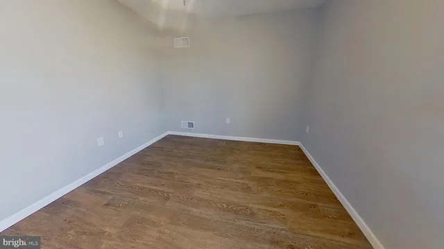 a view of a room with wooden floor and a ceiling fan