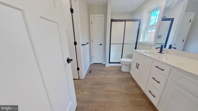 a spacious bathroom with a double vanity sink a mirror and a shower
