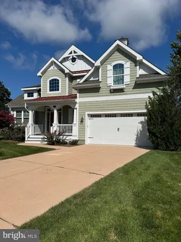 a front view of a house with yard and parking