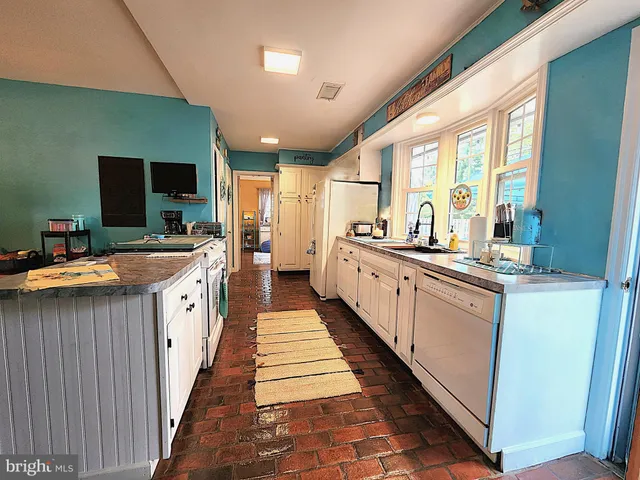 a large kitchen with kitchen island a large counter space a sink a stove and a refrigerator