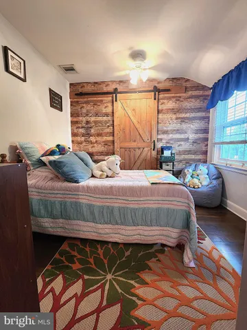 a bedroom with a bed window and a flat screen tv