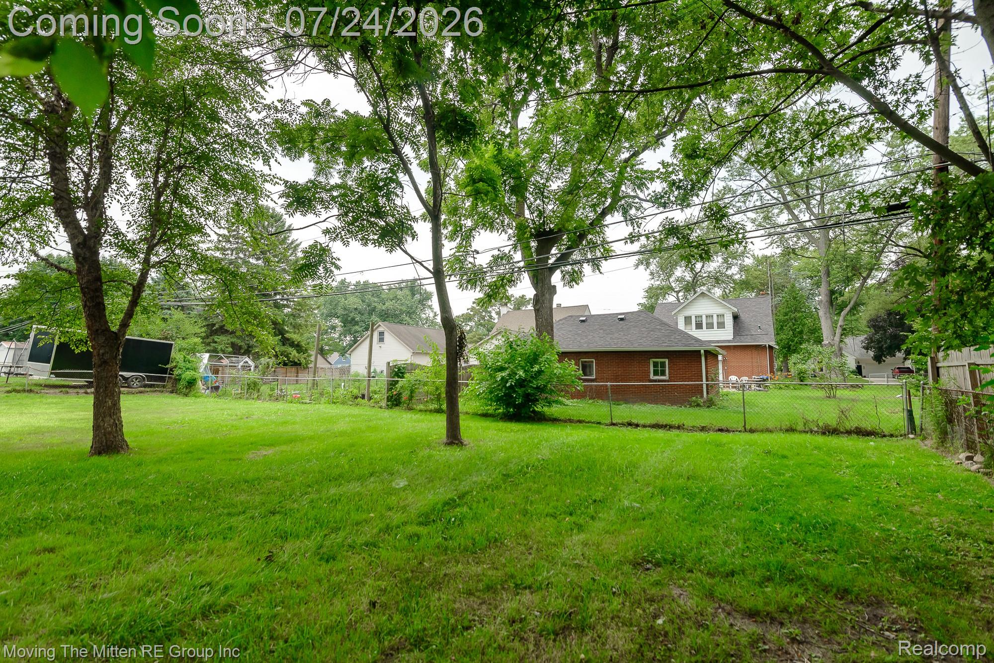 2037 Vivian Road Monroe, MI 48162 - Photo 30 of 39 Expansive grassy yard area featuring mature trees and a chain-link fence
