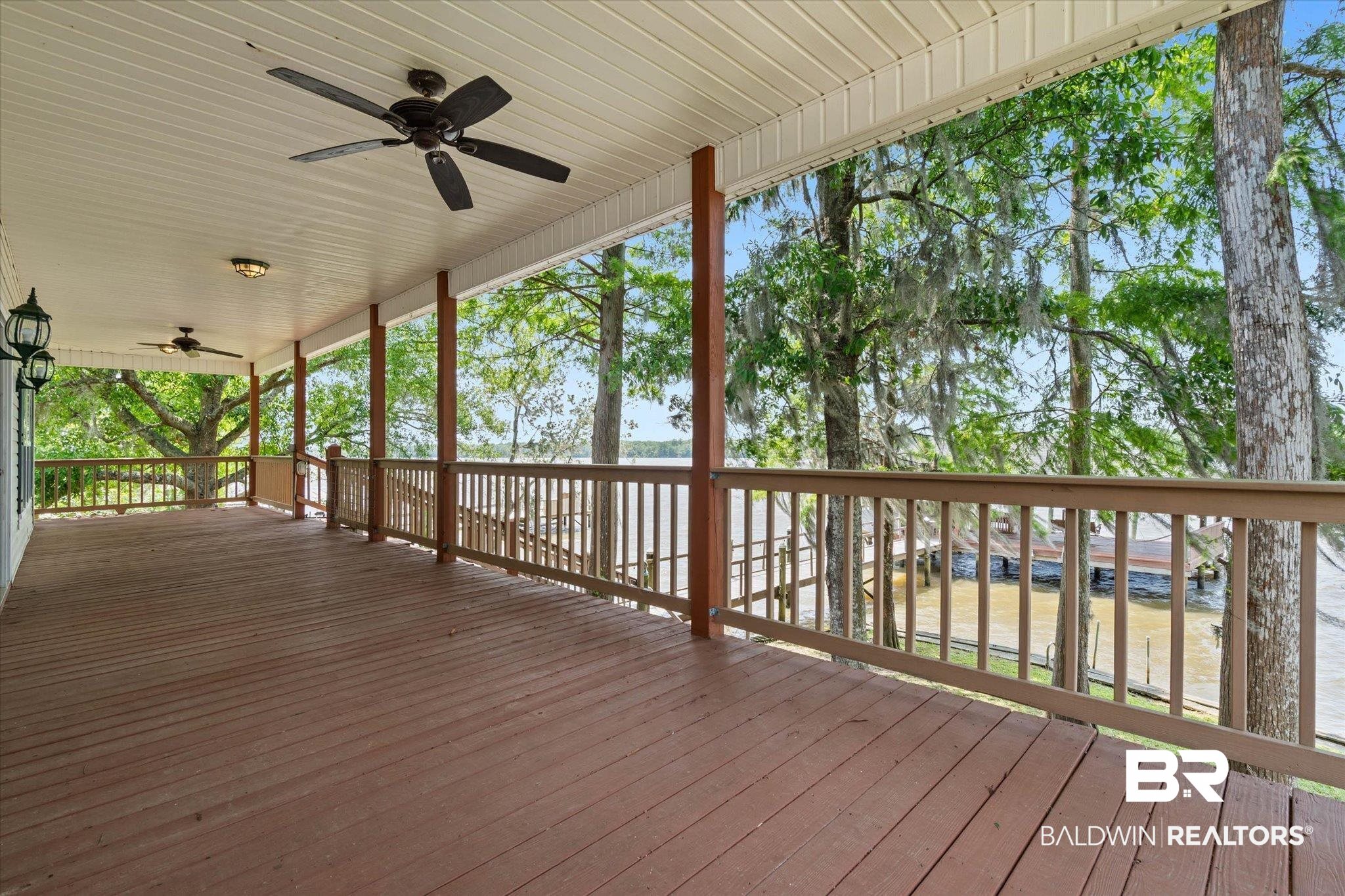 41923 Bayou Road Bay Minette, AL 36507 - Photo 23 of 35 Expansive covered porch featuring wood-finish decking, multiple ceiling fans, and an outdoor light fixture