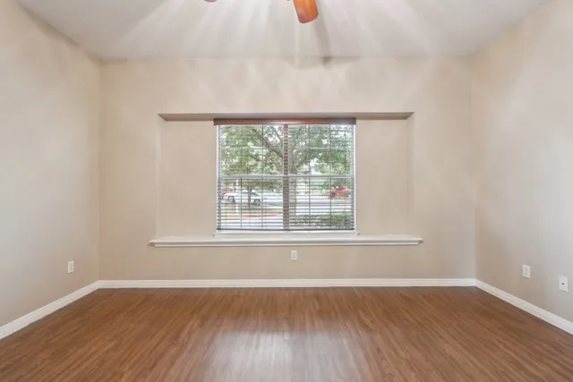 a view of an empty room with wooden floor
