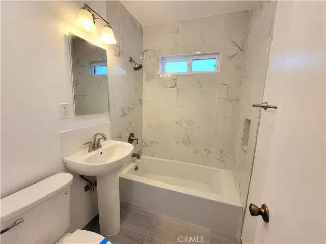 a bathroom with a sink mirror toilet and bathtub