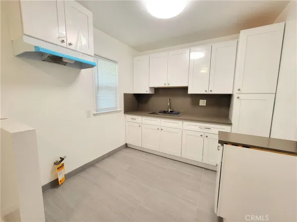 a kitchen with granite countertop white cabinets and white appliances