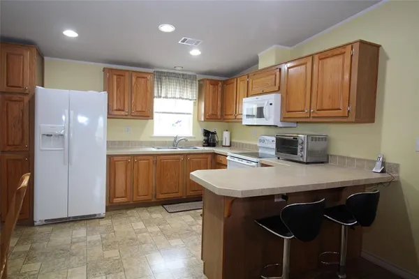 a kitchen with a refrigerator a sink and cabinets