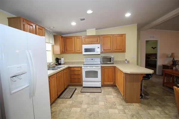 a kitchen with stainless steel appliances granite countertop a refrigerator sink and stove