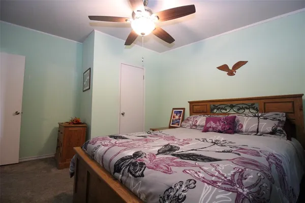a bedroom with a large bed and a chandelier