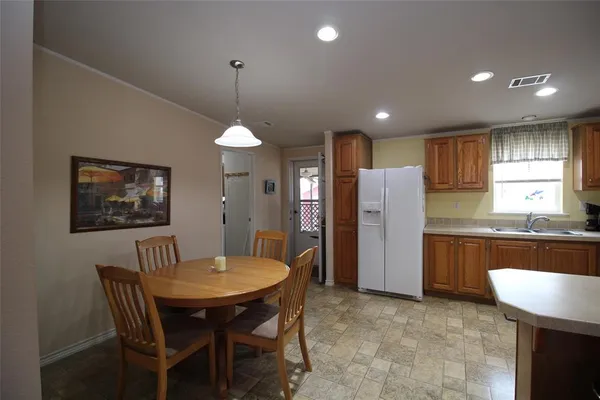 a kitchen with refrigerator a sink and chairs