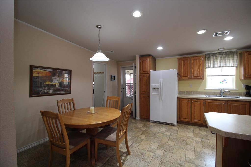601 Carothers Avenue Rochester, TX 79544 - Photo 10 of 37 a kitchen with refrigerator a sink and chairs