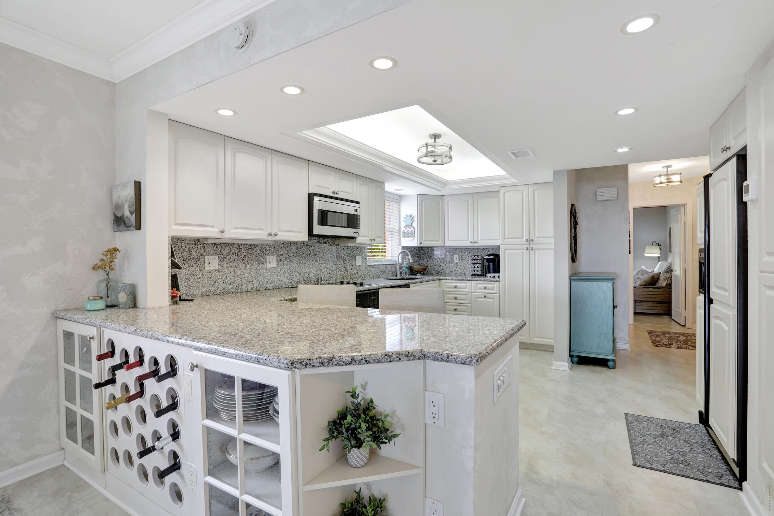 1040 Banyan Road, Unit 301C Boca Raton, FL 33432 - Photo 17 of 49 a large kitchen with stainless steel appliances granite countertop a sink a stove a refrigerator a washer and dryer