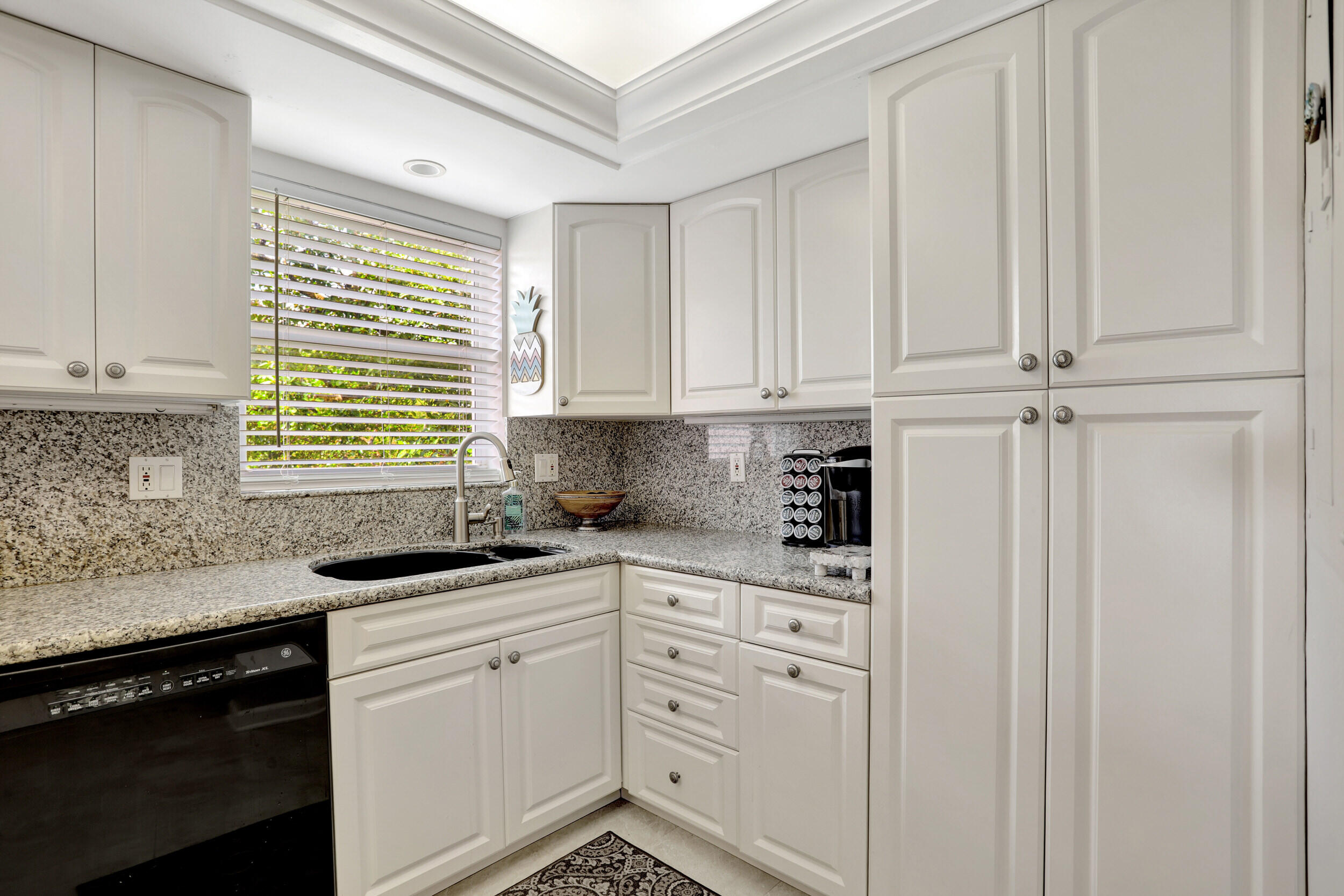 1040 Banyan Road, Unit 301C Boca Raton, FL 33432 - Photo 18 of 49 a kitchen with stainless steel appliances granite countertop white cabinets sink and window