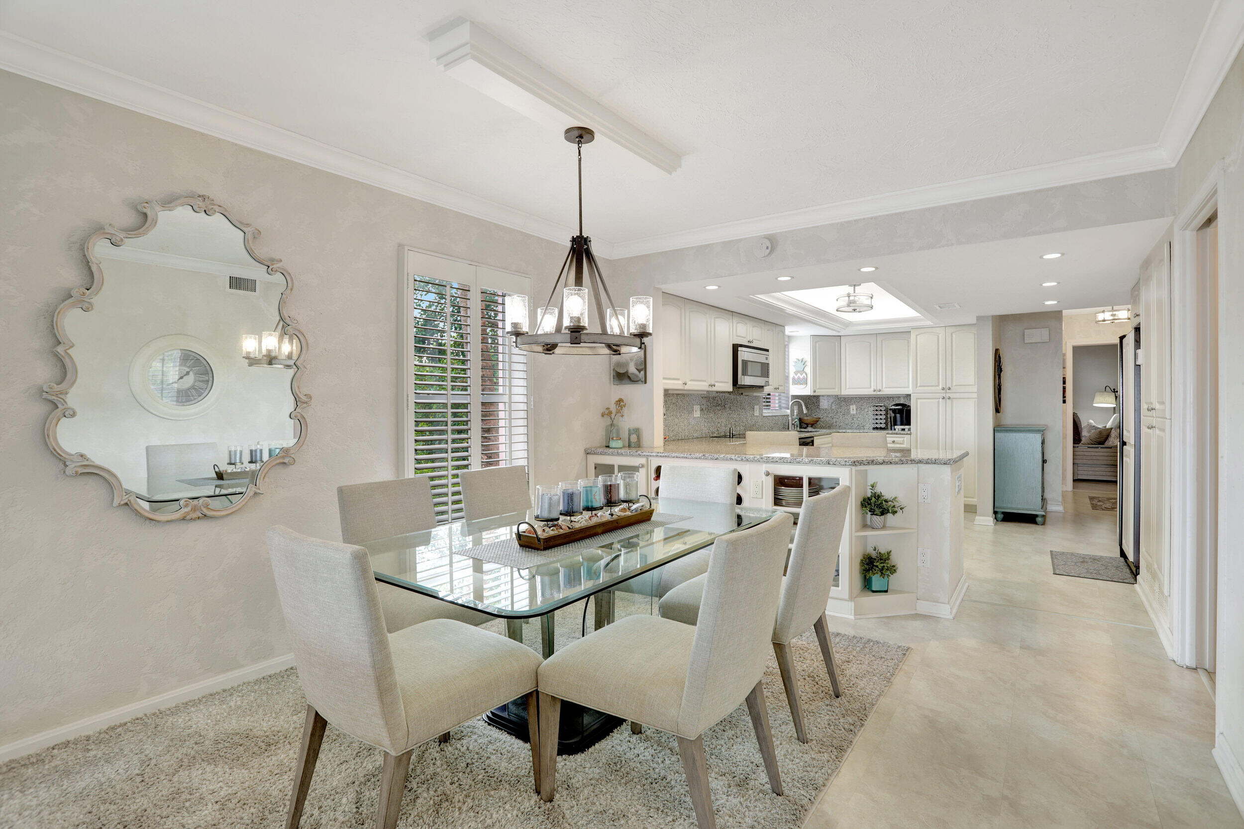 1040 Banyan Road, Unit 301C Boca Raton, FL 33432 - Photo 20 of 49 a kitchen with stainless steel appliances kitchen island granite countertop a dining table chairs and a refrigerator