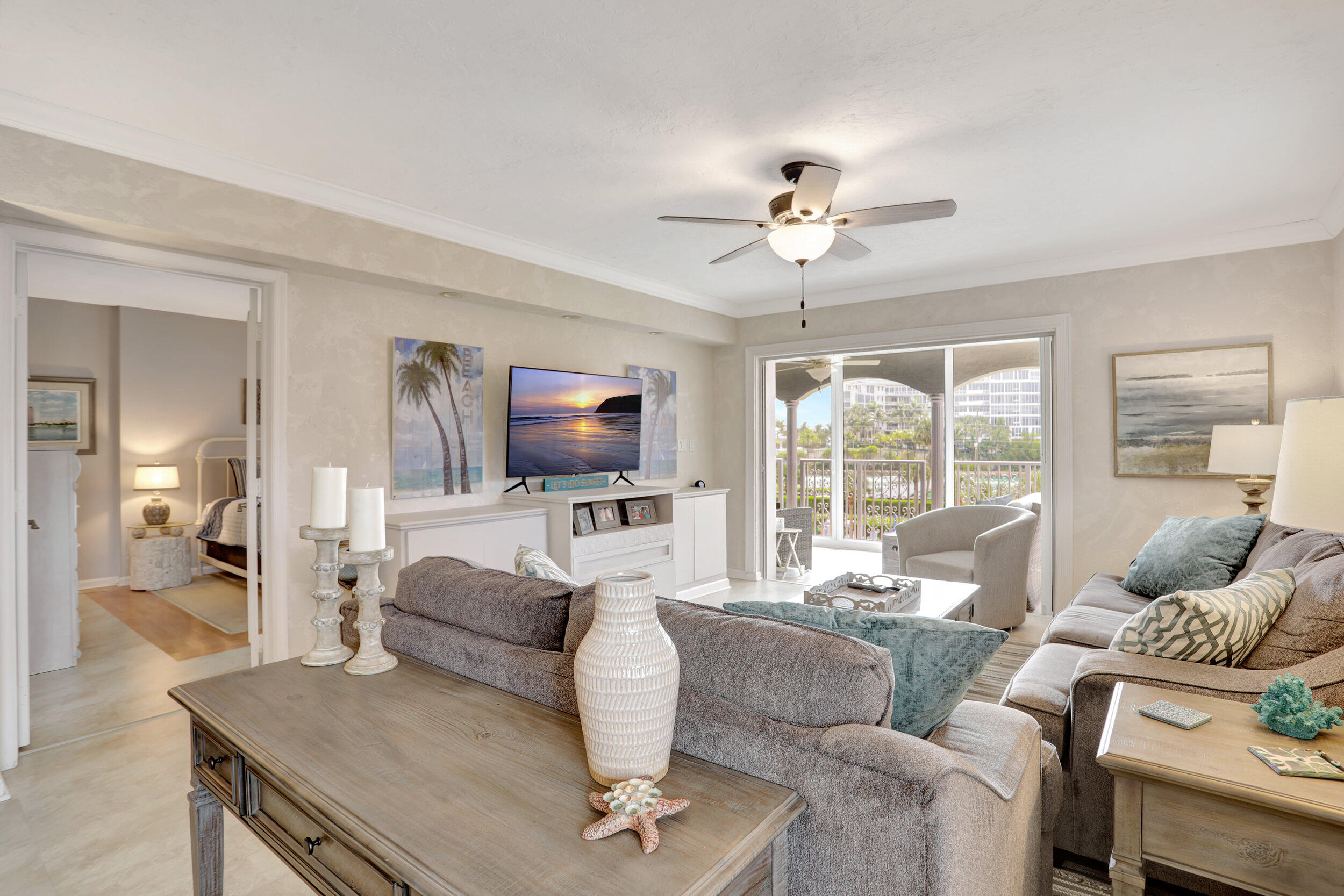 1040 Banyan Road, Unit 301C Boca Raton, FL 33432 - Photo 22 of 49 a living room with furniture a large window and a flat screen tv