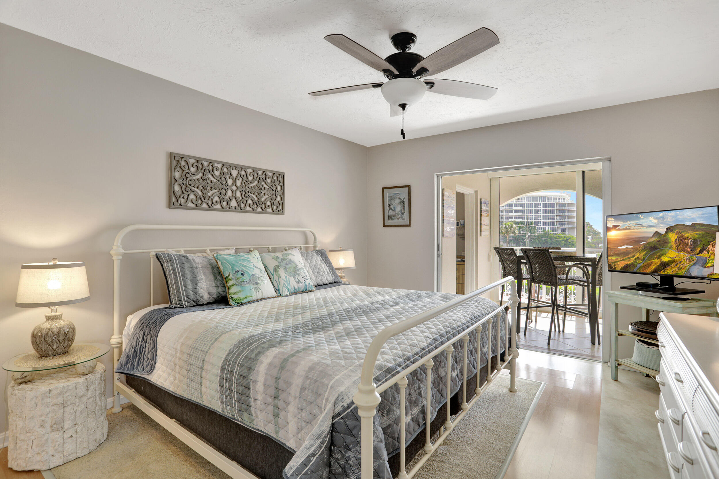 1040 Banyan Road, Unit 301C Boca Raton, FL 33432 - Photo 28 of 49 a bedroom with a bed a chandelier and dresser
