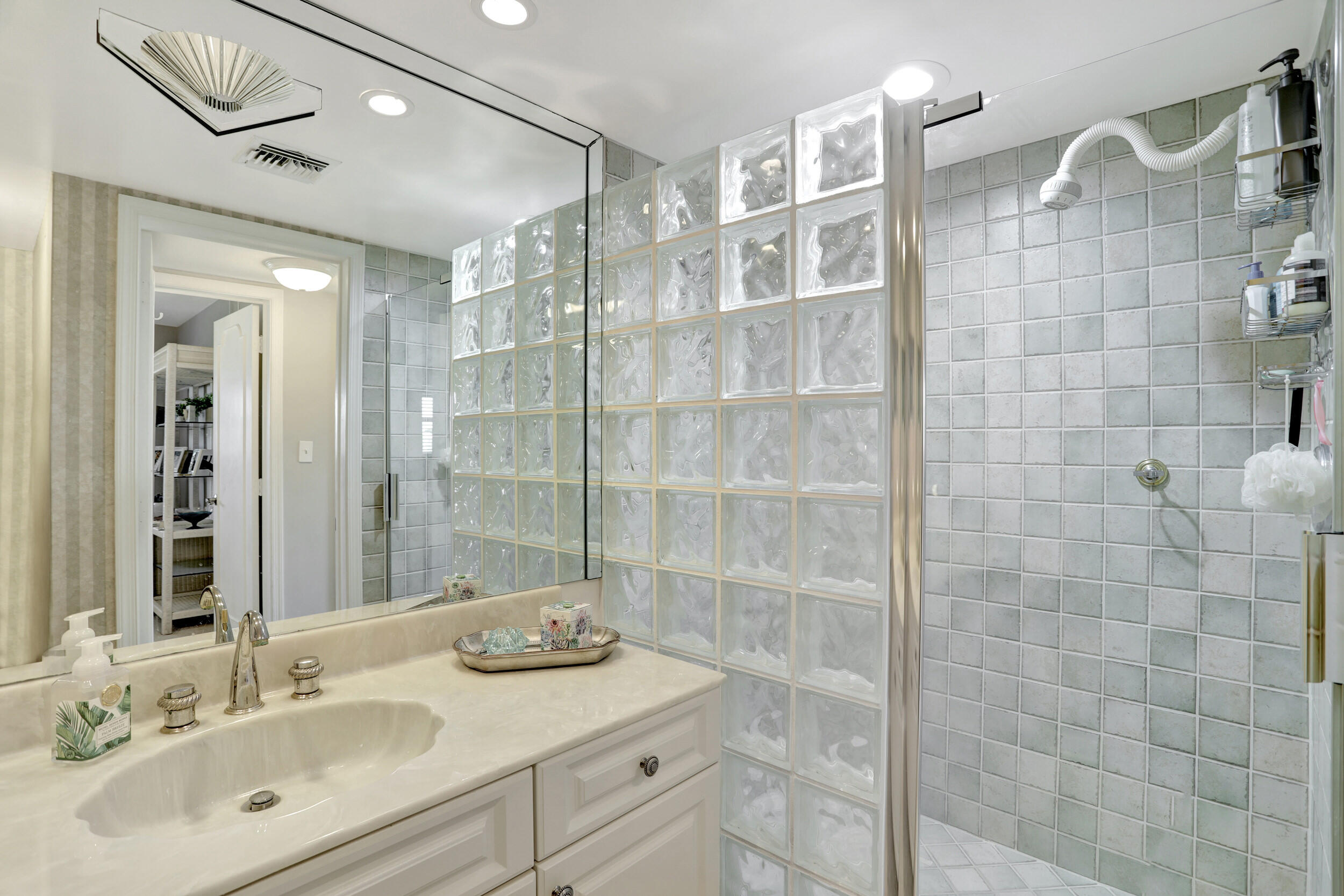 1040 Banyan Road, Unit 301C Boca Raton, FL 33432 - Photo 34 of 49 a bathroom with a sink shower and a mirror