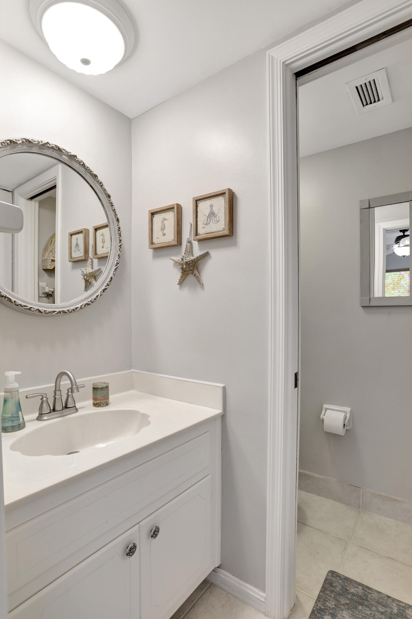 1040 Banyan Road, Unit 301C Boca Raton, FL 33432 - Photo 39 of 49 a bathroom with a sink mirror vanity and toilet