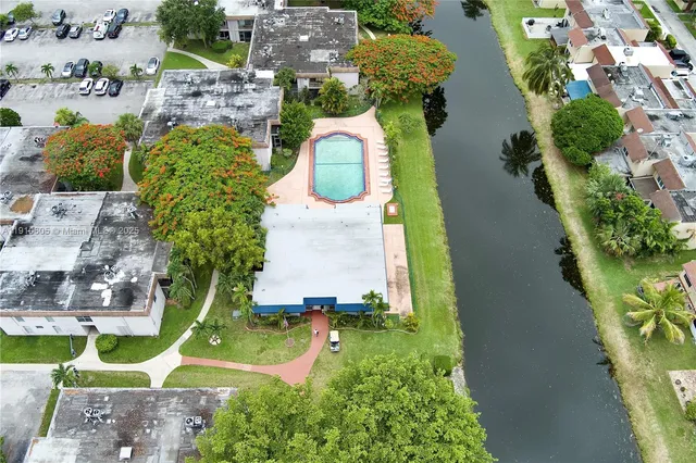 an aerial view of a house with a yard and swimming pool