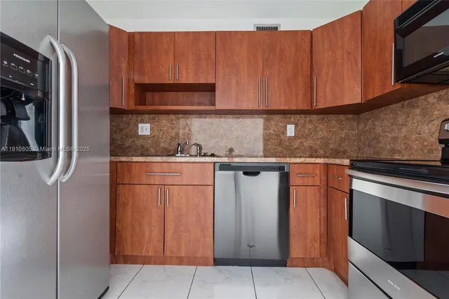a kitchen with stainless steel appliances granite countertop a refrigerator and a sink
