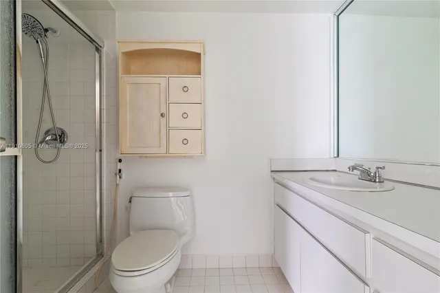 a bathroom with a granite countertop toilet sink and mirror