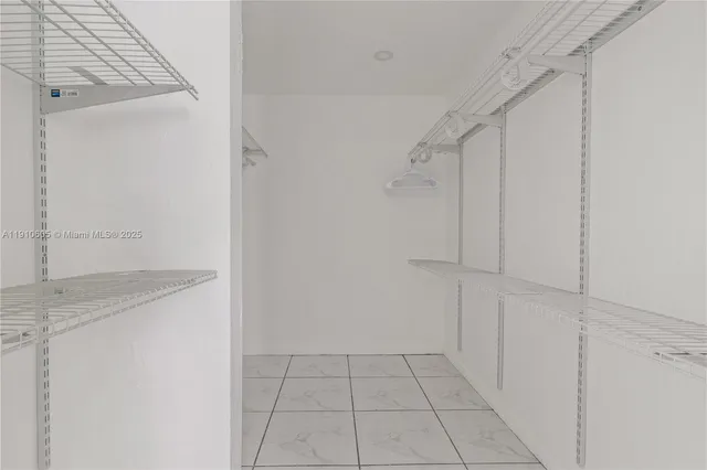 a view of walk in closet with white walls