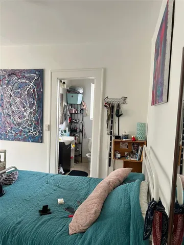 a bed room with a bed furniture and a flat tv screen