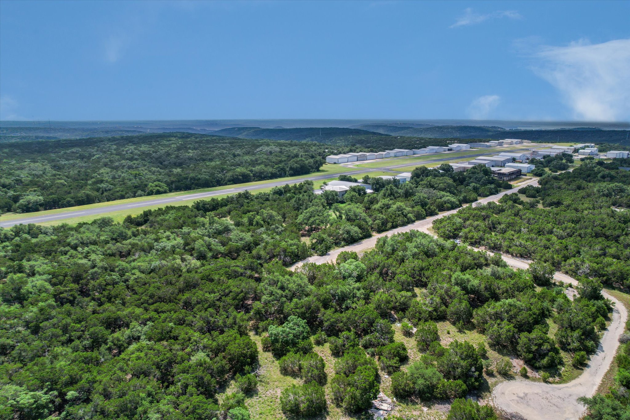 9404 Bar K Ranch Road Leander, TX 78645 - Photo 2 of 12 A tranquil, tree-lined landscape offers a private airstrip and adjacent hangar facilities.