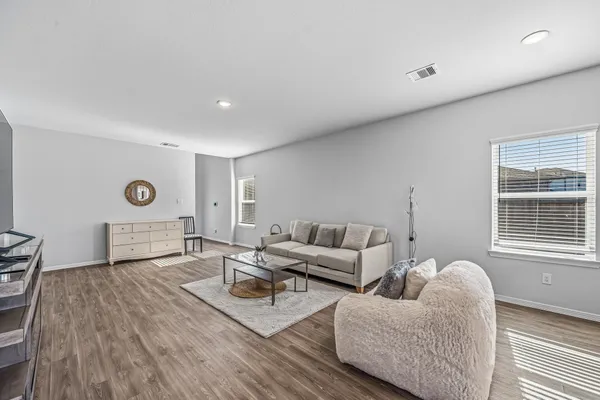 a kitchen with stainless steel appliances granite countertop wooden floor a dining table and chairs