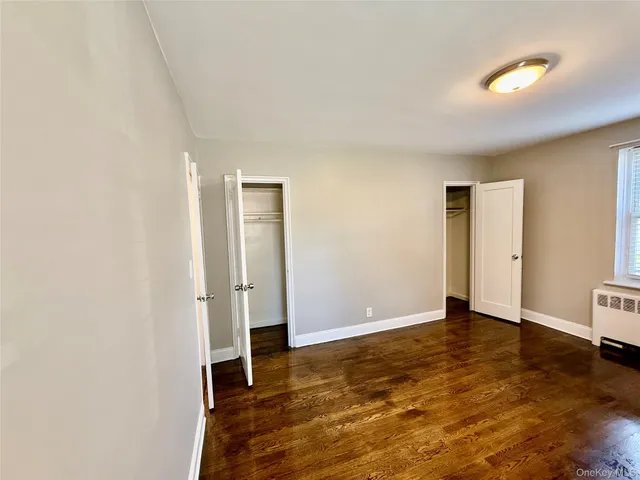 an empty room with wooden floor and closet
