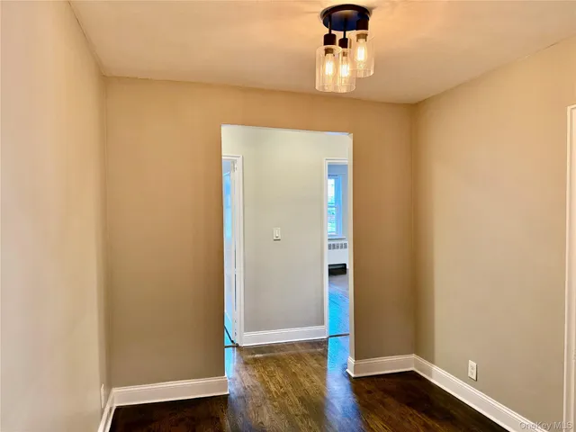 an empty room with wooden floor chandelier fan and wooden floor