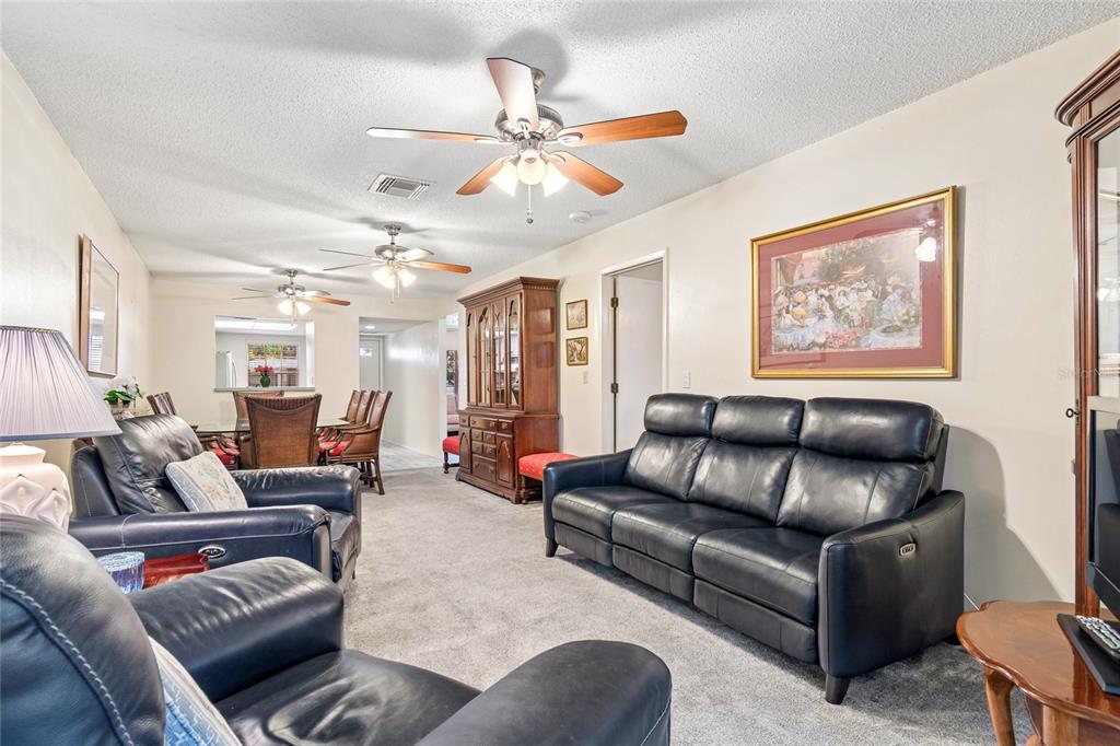 11340 Carriage Hill Drive, Unit 4 Port Richey, FL 34668 - Photo 14 of 36 a living room with furniture ceiling fan and a rug