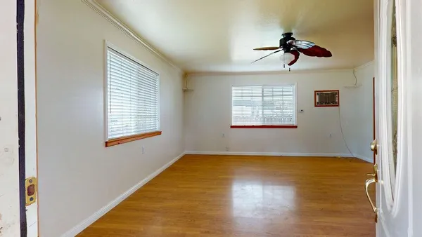 a view of a room with a window and wooden floor
