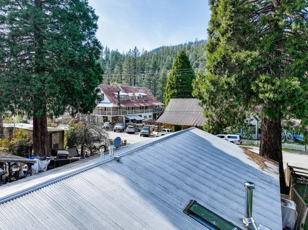 an aerial view of residential houses with outdoor space and trees