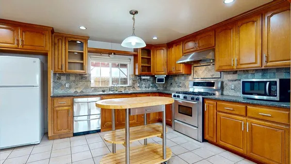 a kitchen with stainless steel appliances granite countertop a sink stove and cabinets
